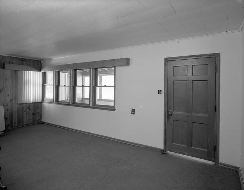 View facing northeast of east wall in living room, interior view of original windows and doors.