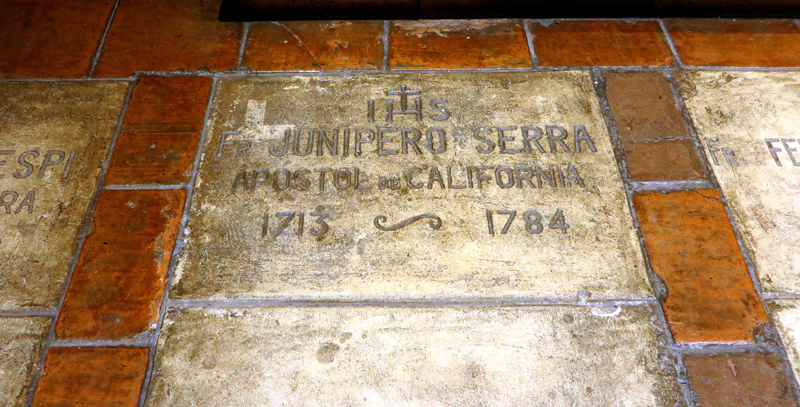 Fr. Junipero Serra is entombed in a crypt beneath his  headstone next to the altar.