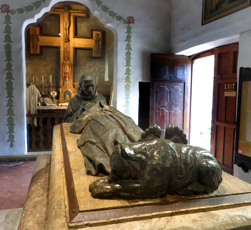 Fr. Serra's feet rest on the likeness of a grizzly bear as Fr. Juan Crespi stands over him.